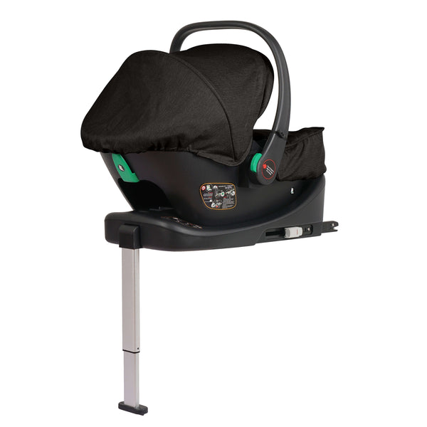 Black infant car seat with canopy, green handle accents, shown on base