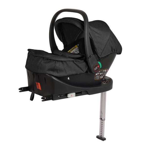 Black infant car seat with canopy and green handle, front view on base with stand