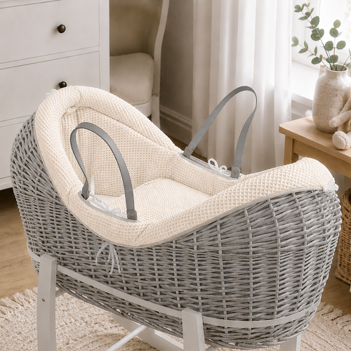 Dark grey wicker Moses basket with cream waffle-pattern liner on white stand