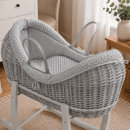 Grey wicker baby moses basket on white stand with padded grey waffle bedding
