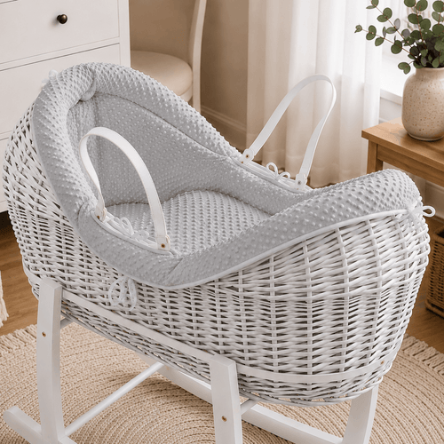 Grey wicker baby moses basket on white stand with padded grey waffle bedding