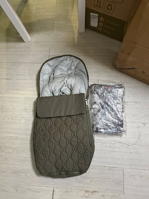 Moss quilted carrycot cover and wrapped fabric bundle, on floor