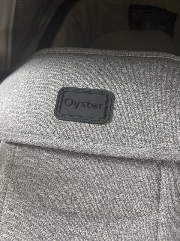 Oyster label on grey carrycot fabric cover