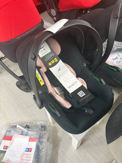 Newborn car seat with pink padded insert and dark shell, front harness and headrest