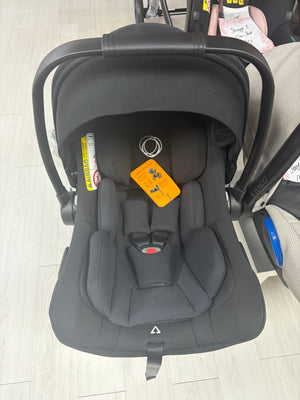 Black baby car seat with canopy, padded harness, and recline base
