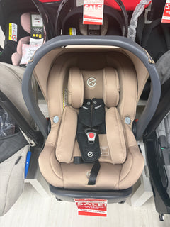 Beige baby capsule car seat with gray frame, padded harness and headrest