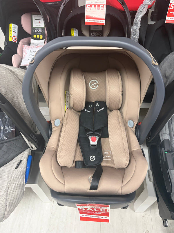 Beige baby capsule car seat with gray frame, padded harness and headrest