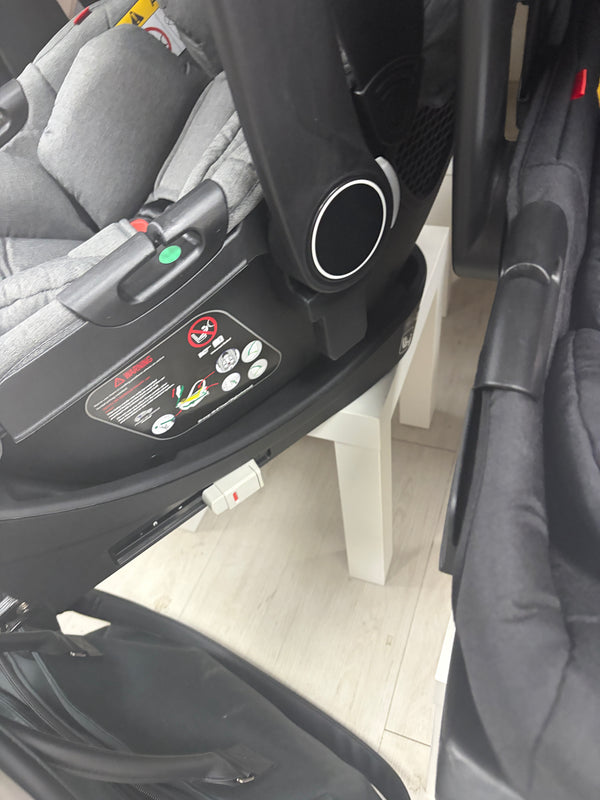 Newborn car seat ISOFIX base with green belt indicators and grey shell