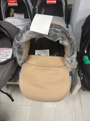 Cream newborn car seat with padded insert, wrapped in protective plastic