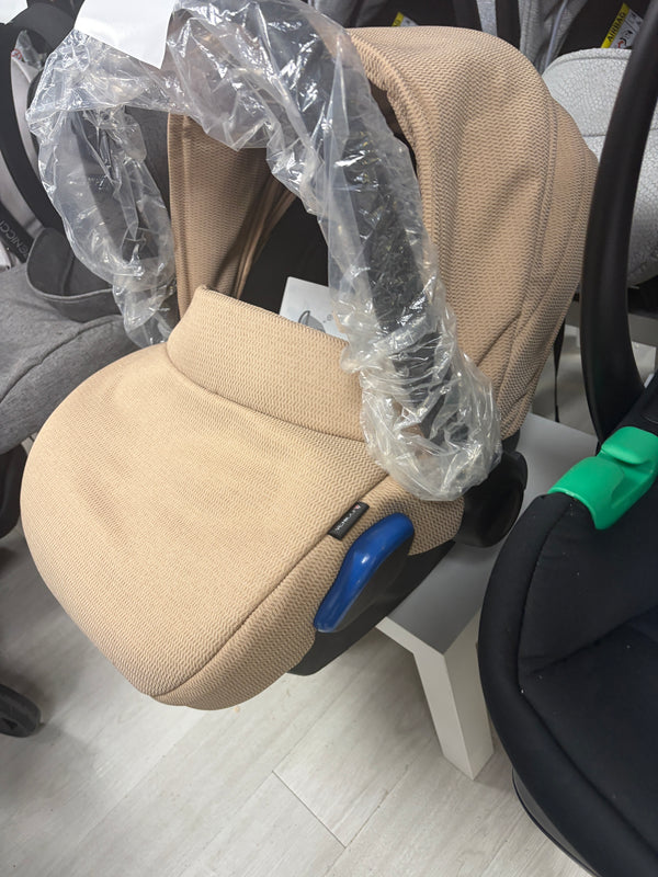 Cream newborn car seat with padded seat, blue adjustment bar and black frame