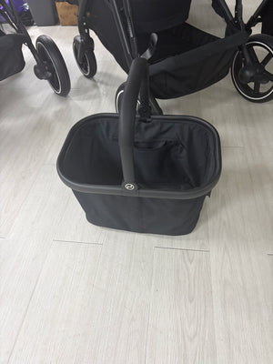 Black carrycot with padded sides, large base and carry handle at the front