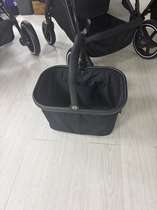 Black carrycot with padded sides, large base and carry handle at the front