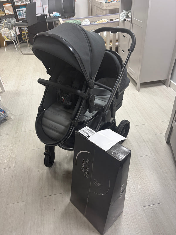 Dark gray tandem stroller with two seat units and carrycot