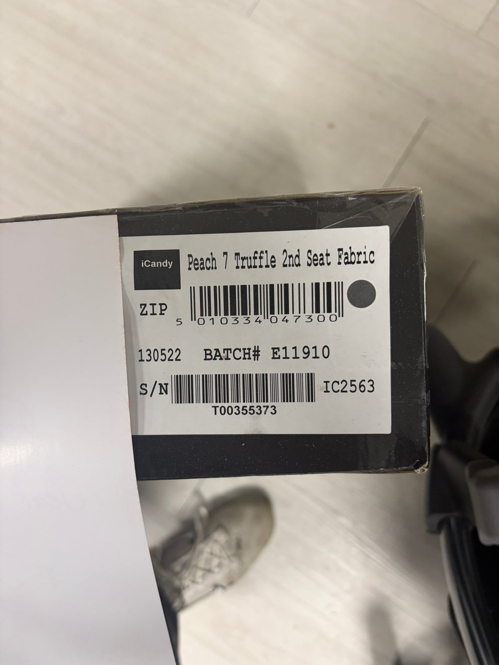 Dark gray tandem stroller with two seat units and carrycot