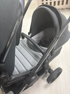 Dark gray stroller seat with hood and padded footrest