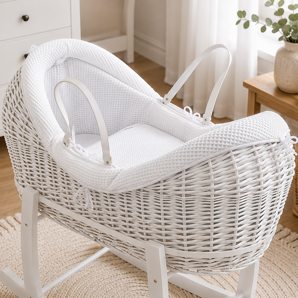 White wicker baby crib in a nursery with toys and decor.