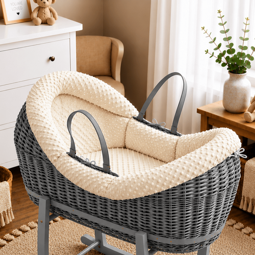Gray wicker baby bassinet with cream interior in a nursery setting