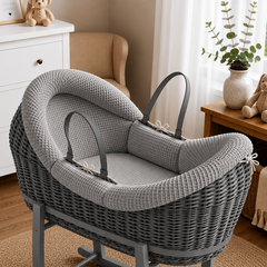 Gray wicker baby Moses basket with stand in a nursery setting