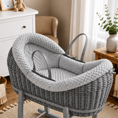 Gray wicker baby crib with gray cushion in a nursery setting