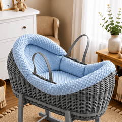 Gray wicker baby crib with blue cushion in a nursery setting